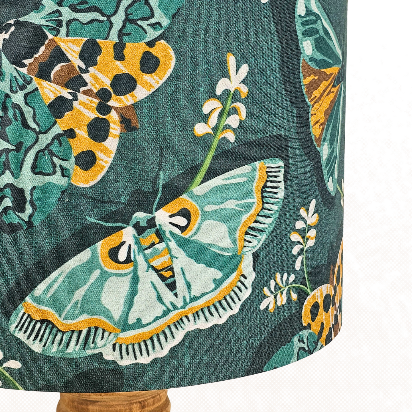 Close up of lampshade with green and yellow moths and white flowers